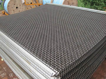 A stack of crimped trommel screen mesh with hooked edge.